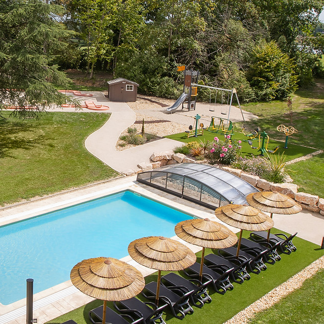 Outdoor swimming pool with lounge chairs and parasols at Château de Montsymond