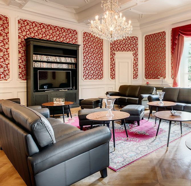 Elegant salon at Château de Montsymond with black leather sofas