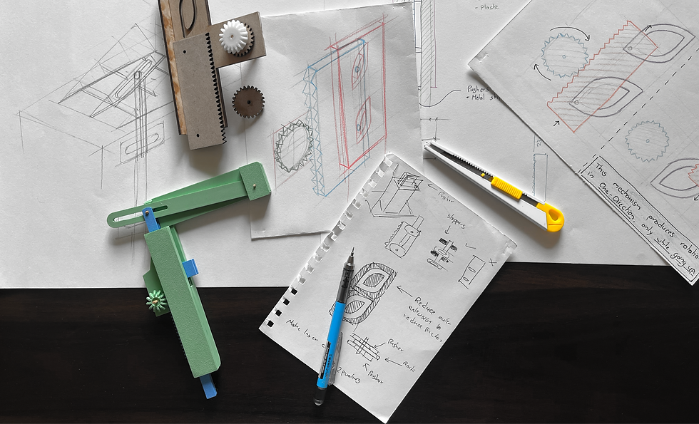 Technical sketches and tools on a dark surface, featuring a yellow utility knife, gears, and a green device. Plans depict mechanical concepts.