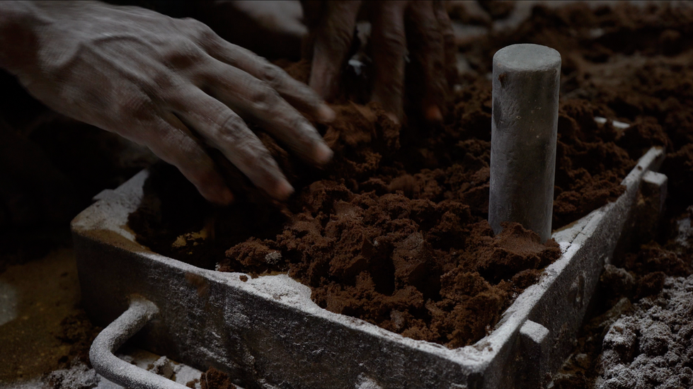 Manual sand mould shaping process using hands and tools for casting metal parts