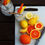 Thumbnail: Top view of a white cutting board with mason jars of ice water, citrus fruit, knife and stainless-steel straws