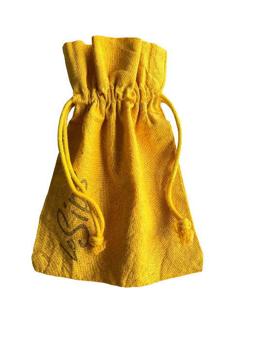 Thumbnail: Closeup of a hand dyed solid color yellow drawstring travel bag with the word LeSips stamped along the side