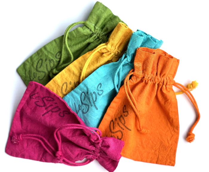 Thumbnail: Top view of five hand dyed solid color drawstring travel bags with the word LeSips stamped along the side