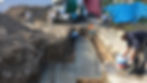 Trabajadores vertiendo concreto premezclado en cimientos.