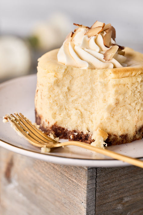 Slice of creamy cheesecake with whipped topping on a wooden stand, Charlotte food photographer