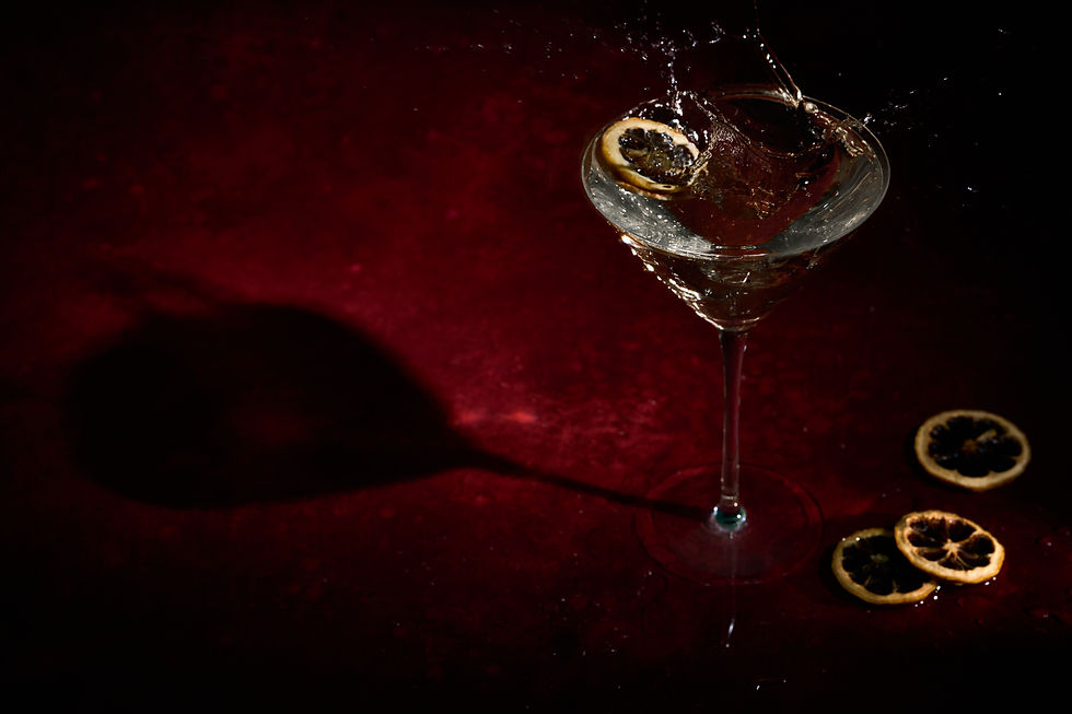 red background, a martini glass with a yellow lemon slice splashing it over the side