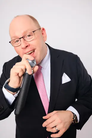 DJ Dan Fudim, a professional NYC DJ, performing with a microphone, bringing high-energy entertainment to events.
