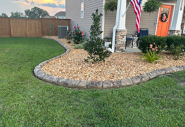 Natural stone landscape curbing creating a focal point around front landscape bed