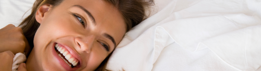 woman in bed with natural beauty representing nakd aesthetics