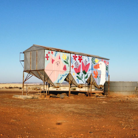 Altes Silo, dessen Fassade einem bunten Bauernhof Motiv aus Ferkel, Gans und Blumen bemalt ist