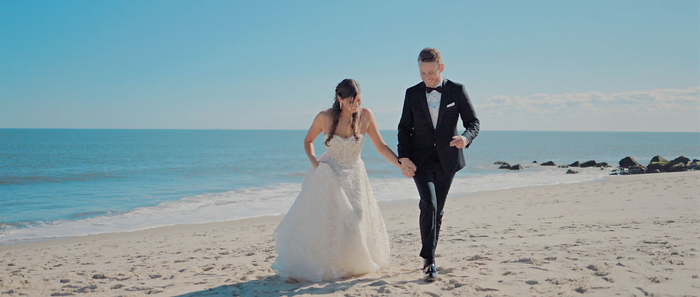 bride and groom holding hands walking on beach