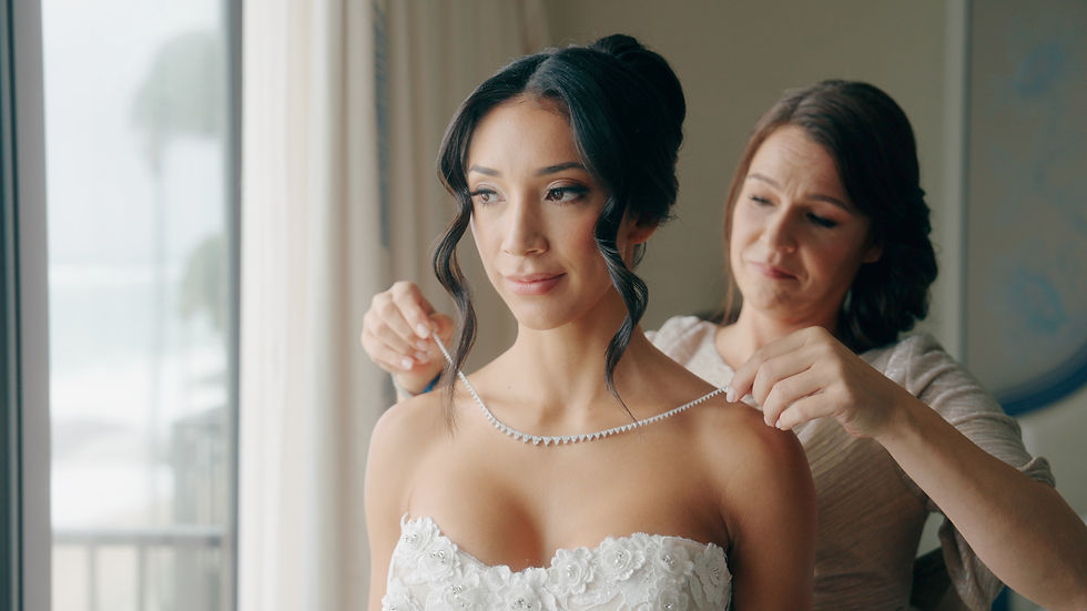 bride having help putting on necklace