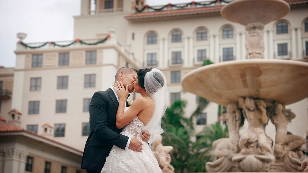 bride and groom kiss by the fountain