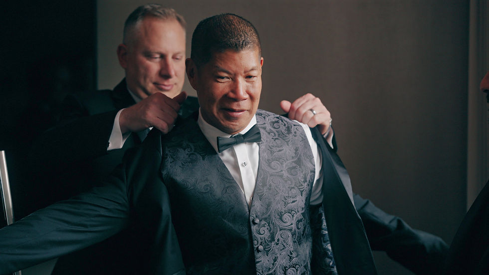 groom putting on jacket on wedding day