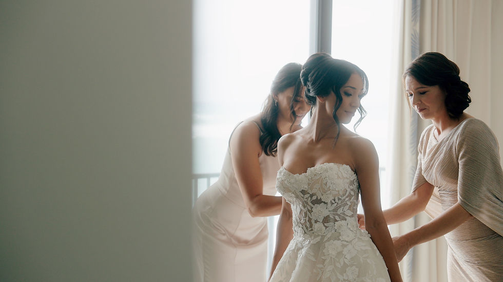 bride having help getting into wedding gown