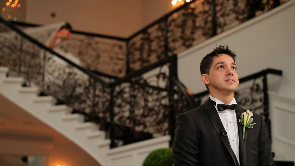 bride descending staircase for her first look on the wedding day