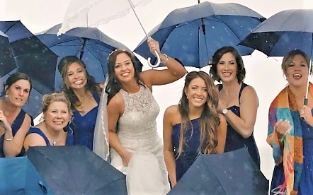 bride and bridal party with umbrellas