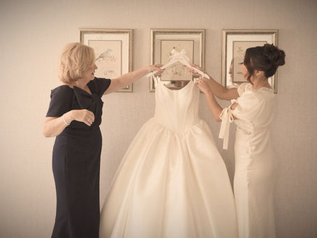 bride and her mother hold her wedding gown