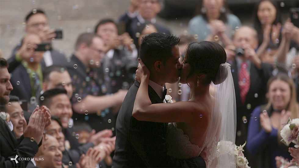 bride and groom kissing after ceremony with bubbles in air