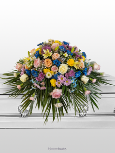 Elegant sympathy casket spray featuring fresh seasonal blooms in soft, soothing tones, designed by bloombudz to honor a loved one with grace and beauty.