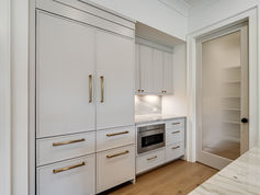 Custom kitchen with oversized island and scullery in Cheval luxury home