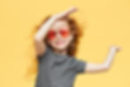 energetic-acitve-cheerful-little-girl-with-wavy-ginger-hair-looking-with-broad-radiant-smi