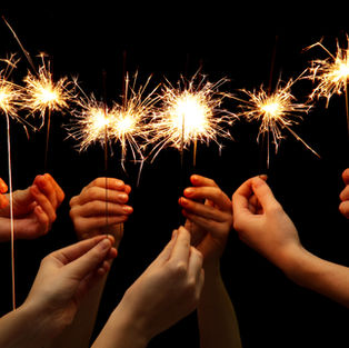 Hands holding sparklers for Fireworks night