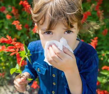 kid holding a handkerchief on nose