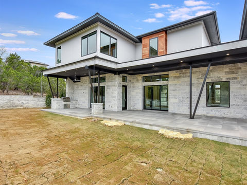 Modern home exterior with stone and large windows. Concrete Struksures CLIENT