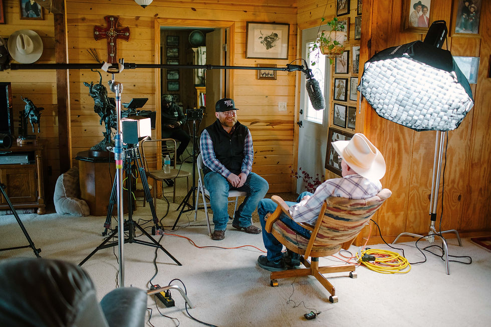 Two men in a room during an interview with microphone and equipment.