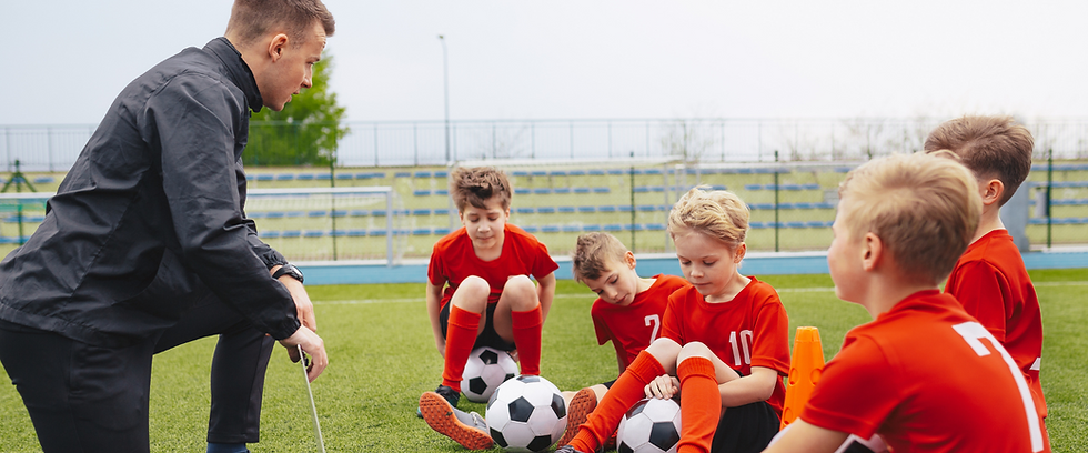 Coach and Soccer Players in a Field