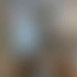 Before renovation: minimal upstairs corner with a simple desk, chair, and window, showing a basic and undecorated salon setup.