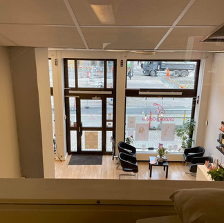 Before renovation: view from upstairs showing the main entrance and waiting area with basic seating and minimal decor.