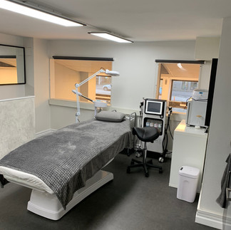After renovation: modern treatment room with a comfortable treatment bed, advanced skincare equipment, and clean, sleek design.