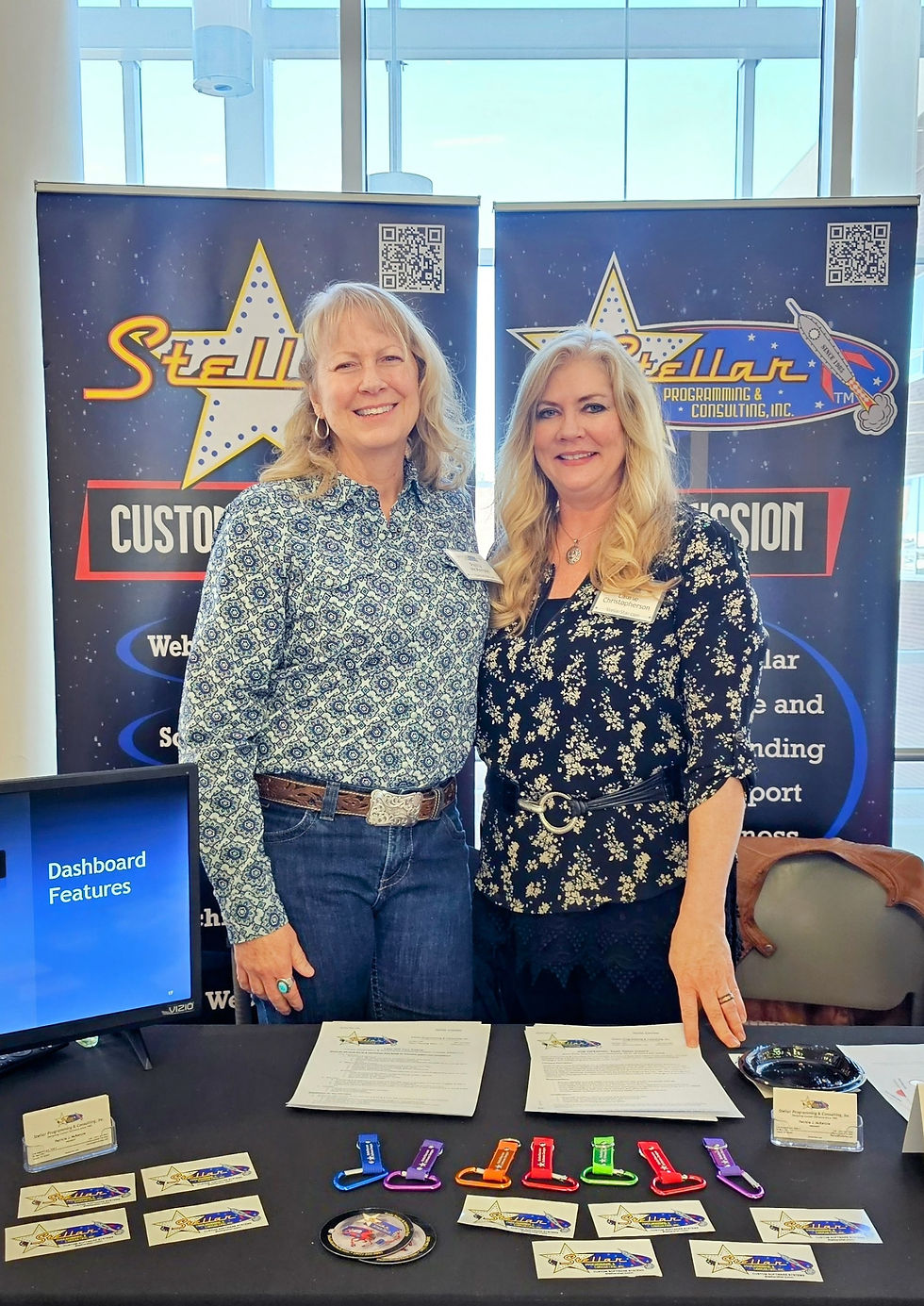 Patty and Laurie stand in front of their booth supporting Casper College at a job fair.