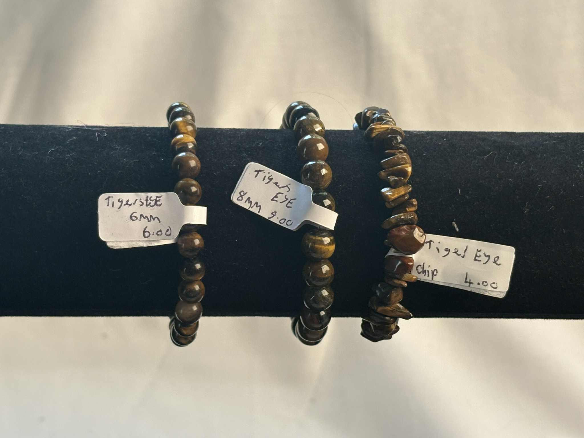 Three Tiger Eye bracelets on display with price tags