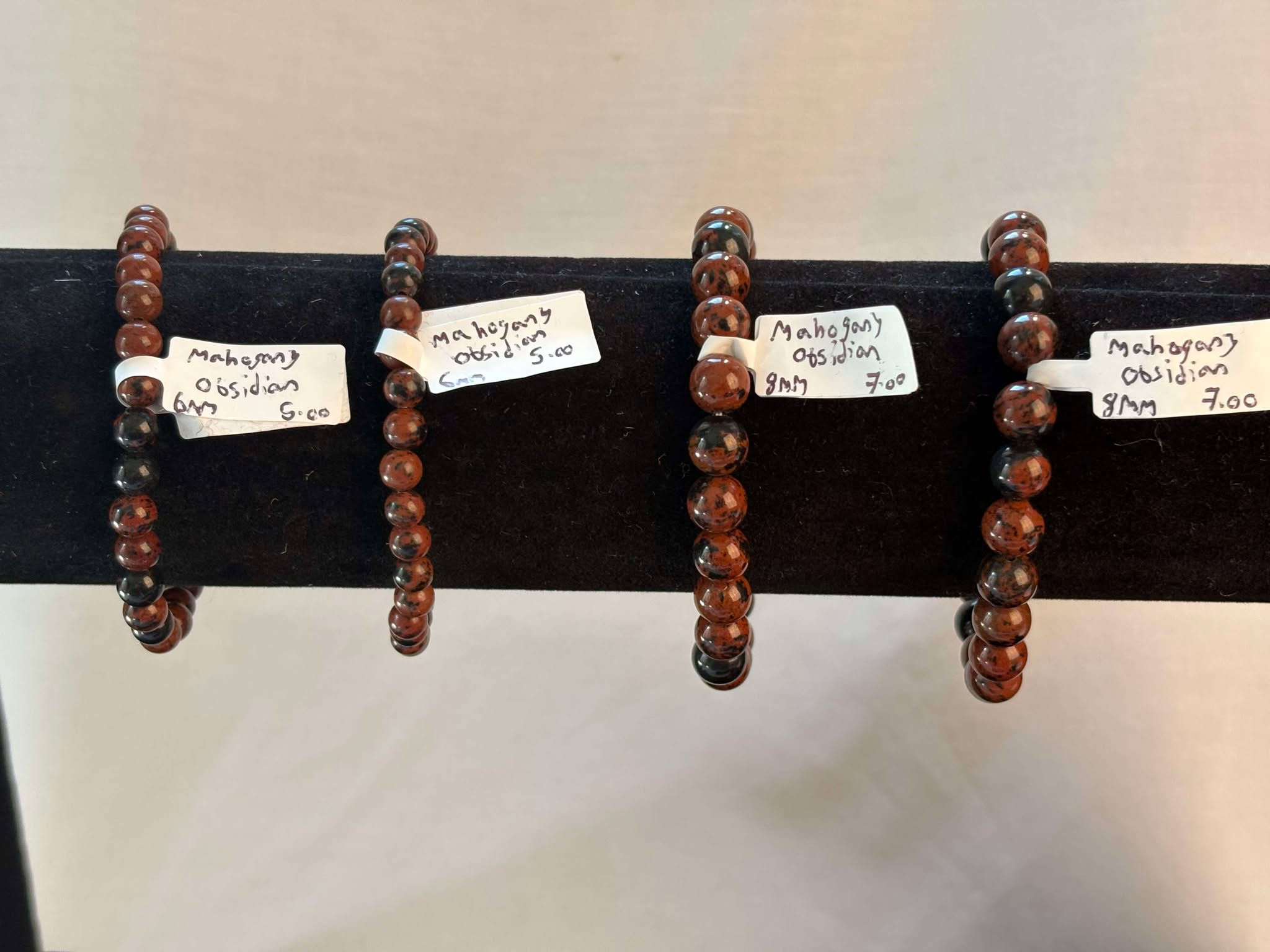 Four bracelets on display with price tags reading
