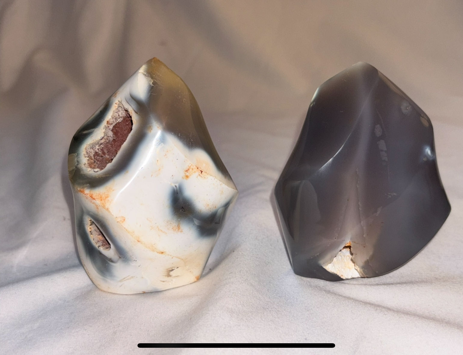 Two polished stones, one white and gray, one gray, with sparkle in stone.