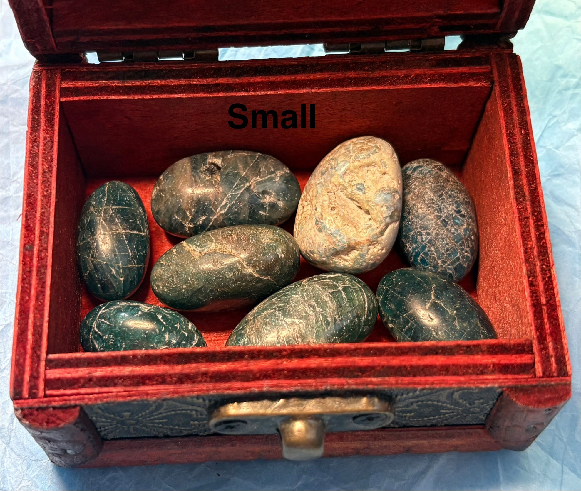Small reads inside a red box with several stones. Ghost Carving Small, treasure chest