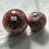 Thumbnail: Two red and white crystal spheres labeled A and B on display.