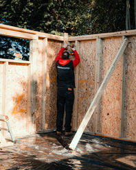 Skilled tradesmen fitting timber cladding to bespoke garden room exterior