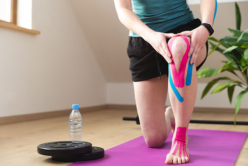 Kinesiotaping, kinesiology. Female athlete with kinesiotape, muscle tape on knee. Wourkout