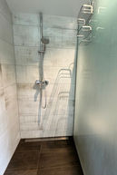 Moderne Dusche mit Holzoptikfliesen und Regalen