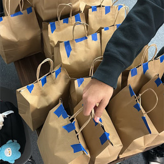 The final result of hard work and teamwork: dozens of completed Community Care Bags, taped shut and 