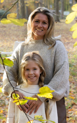 Moeder en dochter samen tijdens een fotoshoot, lachend en verbonden in een liefdevol moment, vastgelegd als dierbare herinnering.