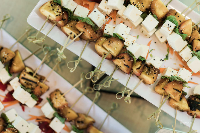 Appetizer skewers with grilled peaches, feta cheese, black sesame seeds. Full service catering.
