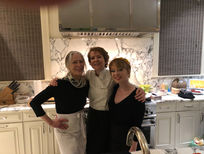Three employees smiling in a kitchen.