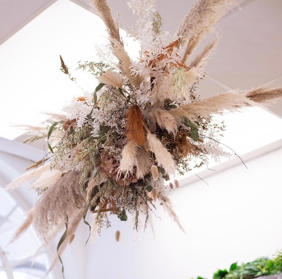 Neutral-toned dried floral arrangement with pampas grass and soft beige textures, styled in a modern interior.