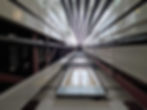Upward view of a modern lift shaft with steel cables and glass panels, suitable for LOLER inspection and lift compliance.