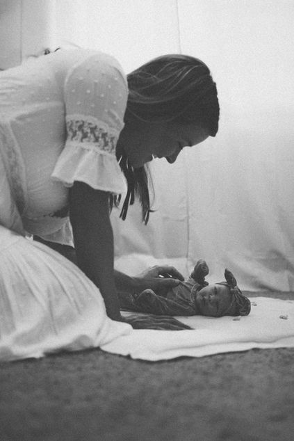 Mother playing with her newborn baby at home